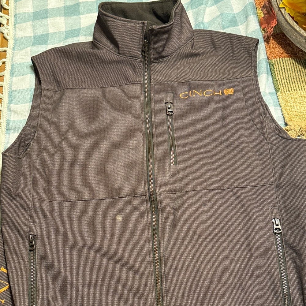 Cinch dark brown vest with tan logo. Size small.